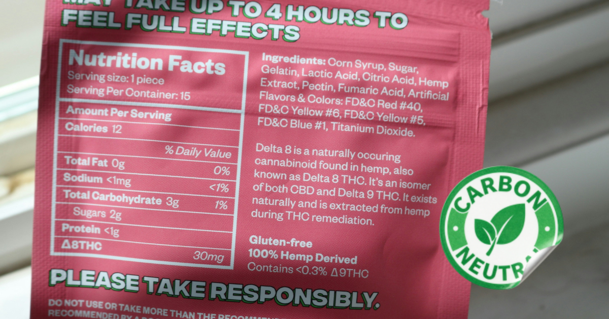 A product label with a carbon neutral sticker being reviewed, illustrating the EU Greenwashing Directive scope.